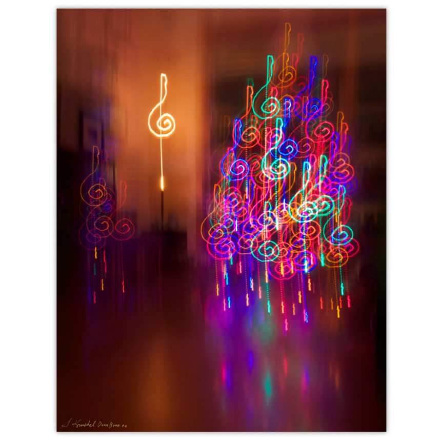 the lights of a Christmas Tree and a candle made to create multiple colourful treble clefs using long exposure and drawing with the camera