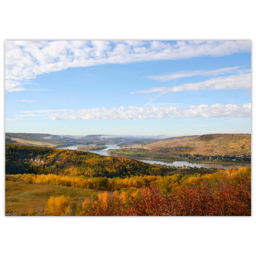 blue sky framed with white clouds on a sunny day over the Peace River valley in the glory of autumn