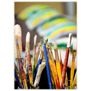 an artist's paintbrushes are displayed like two beautiful bouquets of flowers with art drying in the background