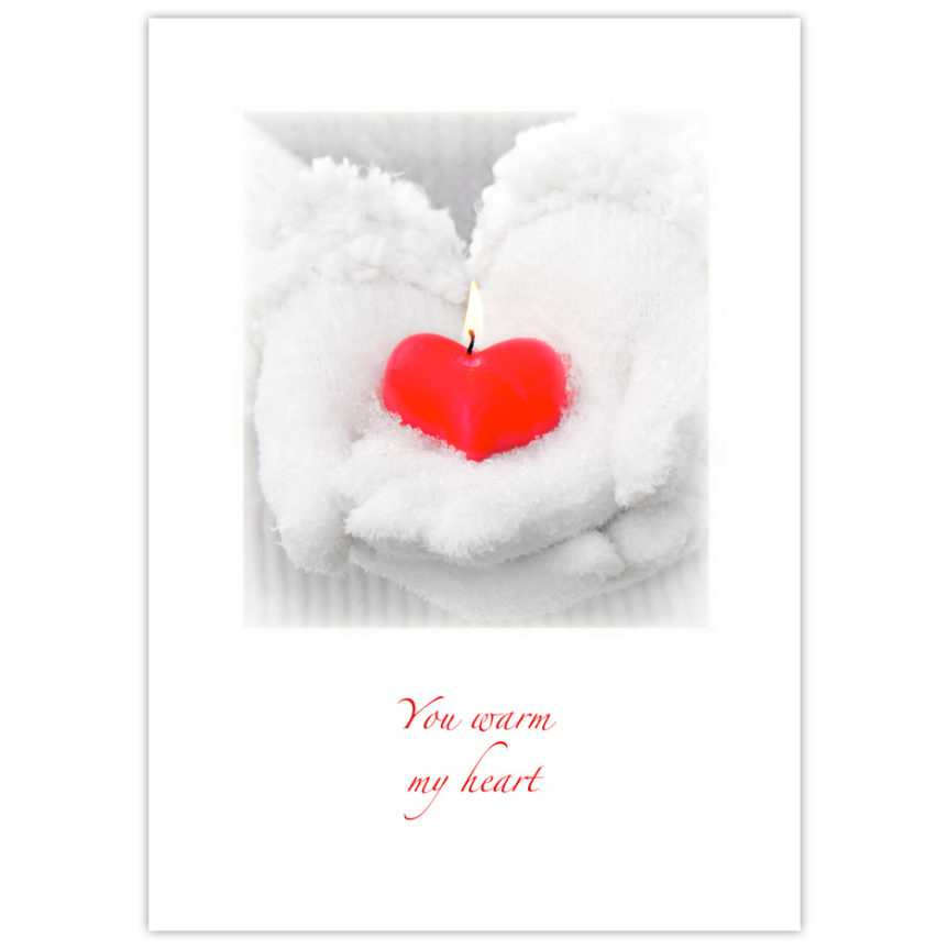 white fluffy snow-covered winter gloves worn by a woman holding a red heart-shaped candle with a flame