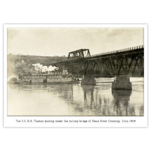 S.S. D.A. Thomas stern-wheel paddleboat passes under the railway bridge at Peace River Crossing, 1919.